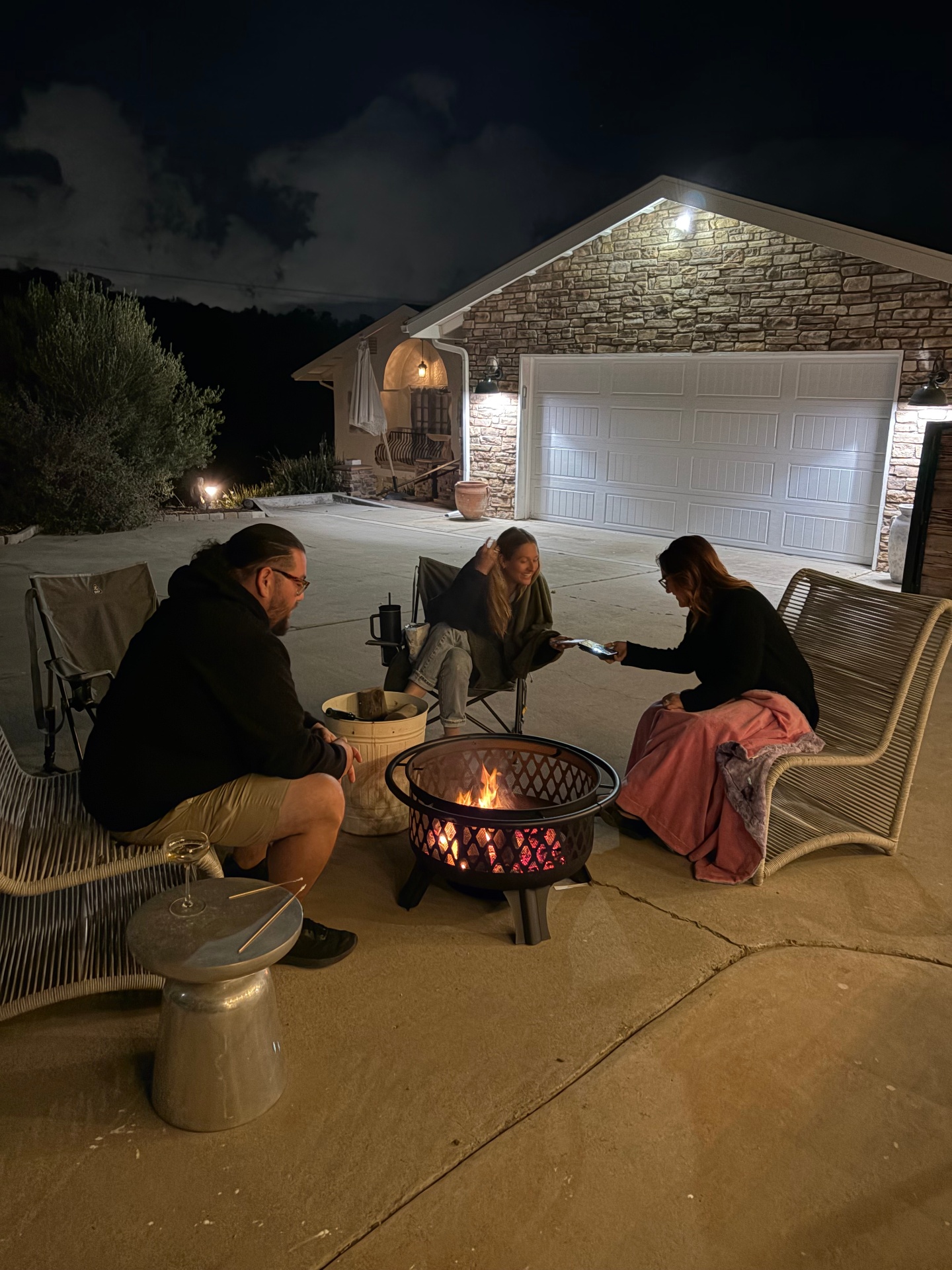 Guests gathered around the fire pit outside at night
